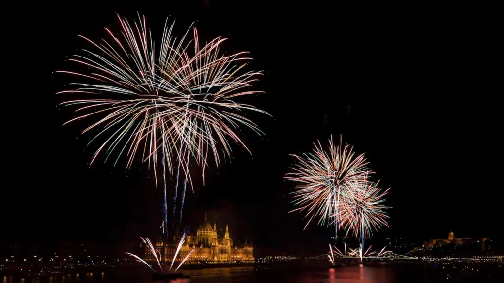 Buntes Feuerwerk über einem ruhigen Gewässer bei Nacht in den Herrenhäuser Gärten.
